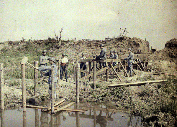 Construction d'une passerelle au dessus des trous d'obus remplis d'eau, dans la région de Boesinghe (Belgique). Autochrome de Paul Castelnau (10/09/1917)