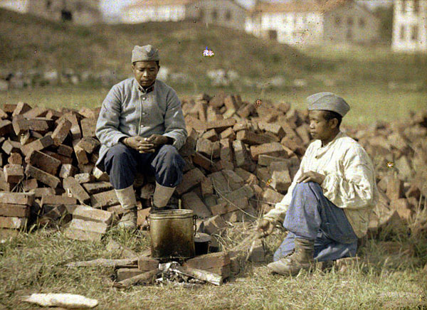 Soldats préparant leur cuisine sur un feu improvisé avec des briques et du bois, à Soissons (Aisne). Autochrome de Fernand Cuville (1917)